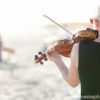 Rearview of Maura playing violin at a Wilmington beach wedding