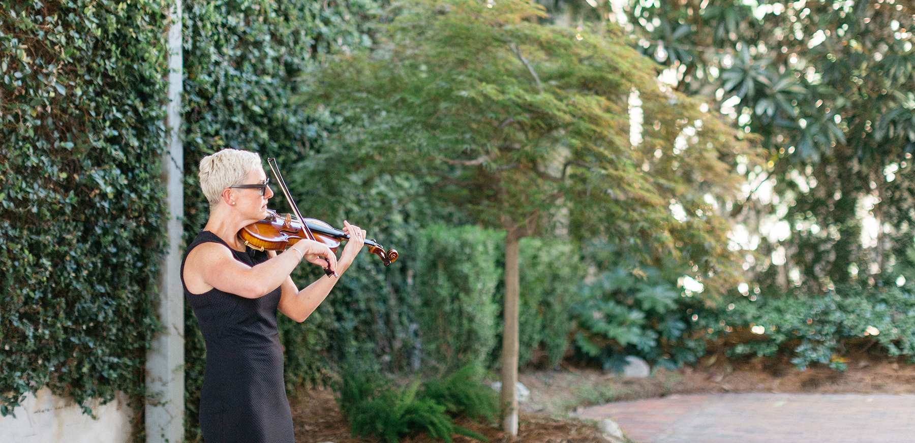 Maura playing violin at an outdoor event