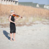 Maura playing violin barefoot in the sand on Wrightsville Beach